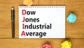 DJIA Dow Jones industrial average symbol. Concept words DJIA Dow Jones industrial average on white note on beautiful wooden