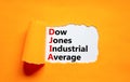 DJIA Dow Jones industrial average symbol. Concept words DJIA Dow Jones industrial average on white paper on beautiful orange