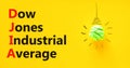 DJIA Dow Jones industrial average symbol. Concept words DJIA Dow Jones industrial average on yellow paper on beautiful yellow