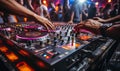 DJs hand adjusting music on turntable at club party with dancing crowd in the background vibrant nightlife scene Royalty Free Stock Photo