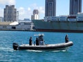 DLNR Police Boat motors through the water in front of Matson container ship in Honolulu Harbor Royalty Free Stock Photo