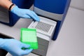 Dna test in the lab. the technician inserts the test tubes into the dna analyzer. Gloved hands close up