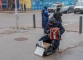 A man plays the button accordion on the street in winter. The inscription in Ukrainian For the treatment of the granddaughter,