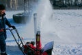 City Municipal Service cleans city streets after heavy snowfall. A man cleans deep snow with