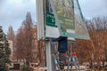 Installation of outdoor advertising in the city. Specialists climb the stairs to the billboard. Work at height