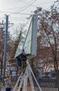 Installation of outdoor advertising in the city. Specialists climb the stairs to the billboard. Work at height