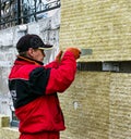 A man installs a layer of thermal insulation in the form of mineral wool panels. Cutting of