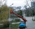 A municipal worker in protective gear replacing bulbs in a street lamp. A worker repairing a Royalty Free Stock Photo