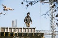 A welder prepares a frame from reinforcement for pouring concrete into the load-bearing girder of a residential building