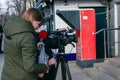 Young journalist and cameraman use a professional video camera to film news in the open air