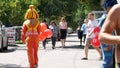 Promoters with colored air balloons on street. Guy and girl in original costumes