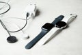 Dnipro, Ukraine - December 10, 2023: Smart watch Samsung Galaxy Active Watch white and black Apple Watch Series 8 lies on a white