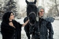 Cosplayers in image of a characters Geralt of Rivia and Yennefer of Vengerberg from the game or film The Witcher next to a horse