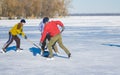 Three mature man fighting for the pack while playing amateur hockey on a frozen river Dnepr in Ukraine Royalty Free Stock Photo
