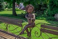 Sculpture of a angel with bow on Family bench on Sicheslavska embankment in Dnipro, close-up.