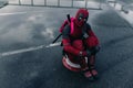 DNIPRO, UKRAINE - MARCH 28, 2019: Deadpool cosplayer posing sitting with weapon