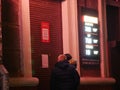 People are standing at closed door of a pawnshop quarantined and reading an notice. Due to threat of spread of coronavirus emergen