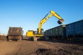 Dnipro, Ukraine - November 19, 2020: CAT crawler excavator at work. Loading raw materials into the car body.