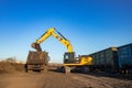 Dnipro, Ukraine - November 19, 2020: CAT crawler excavator at work. Loading raw materials into the car body.