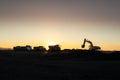 Dnipro, Ukraine - November 19, 2020: silhouette of Excavator loader at construction site with raised bucket over sunset.