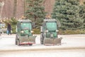 A worker on a tractor removes snow in the city park