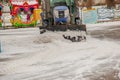 A worker on a tractor removes snow in the city park