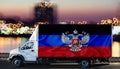 Dnr flag on the side of a white van against the backdrop of a blurred city and river. Logistics concept