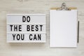 `Do the best you can` words on a modern board, clipboard with blank sheet of paper on a white wooden surface, top view. Overhead Royalty Free Stock Photo