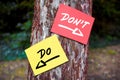 Do and don`t words written on papers on a tree with arrow signs. Dilemma between what to to or not to do