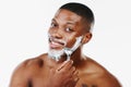 Do I, do I...Love. Studio portrait of a handsome young man applying shaving foam to his beard against a blue background. Royalty Free Stock Photo