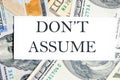 DO NOT ASSUME text, a word written on a white business card against a background of money Royalty Free Stock Photo