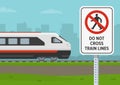 `Do not cross train lines` warning sign for pedestrians on railway. Side view of an approaching train.