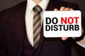 DO NOT DISTURB, message on the card shown by a man, vintage tone Royalty Free Stock Photo