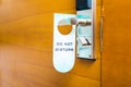 Do not disturb tag hanging on a hotel old wooden door Royalty Free Stock Photo