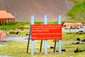 Beware of trespassing sign in abandoned whaling station on Stromness with antarctic fur seal colony in front, South Georgia