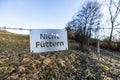 `Do not feed` sign written in german nicht fÃÂ¼ttern hanging on a barbwire at a fields for horses and donkeys