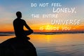 Do not feel lonely-universe inside you. Man silhouette sitting on stone at the seaside contemplating sunset. Inspirational