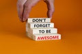 Do not forget awesome symbol. Concept words `Do not forget awesome` on wooden blocks on a beautiful orange background. Businessm
