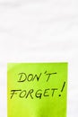 Do not forget handwriting text close up isolated on green paper with copy space. Writing text on memo post reminder