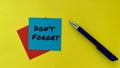 Do not forget - message on blue notepad. With pen and yellow background. Business concept.