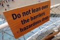 Do not lean over the barriers sign.