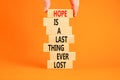 Do not lost hope symbol. Concept words Hope is a last thing ever lost on wooden blocks on a beautiful orange background.