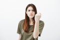 Do not mess with my anger. Portrait of displeased good-looking girlfriend in casual t-shirt, raising clenched fist and