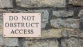 Do Not Obstruct Access sign on stone wall - background banner image