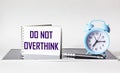 Do not overthink- motivational text on notepad with alarm clock, procrastination, productivity