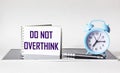 Do not overthink- motivational text on notepad with alarm clock, procrastination, productivity Royalty Free Stock Photo