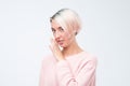 Talkative mysterious pretty beautiful woman with dyed hair dressed in pink sweater is saying secret Royalty Free Stock Photo