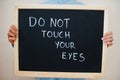 Do not touch your eyes. Coronavirus concept. Boy hold inscription on the board