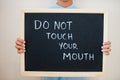 Do not touch your mouth. Coronavirus concept. Boy hold inscription on the board