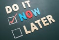 Do It Now or Later with checkbox and red check on blackboard Royalty Free Stock Photo